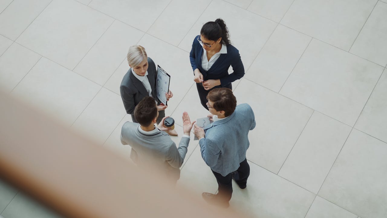 Overhead shot of diverse business team discussing a project indoors.